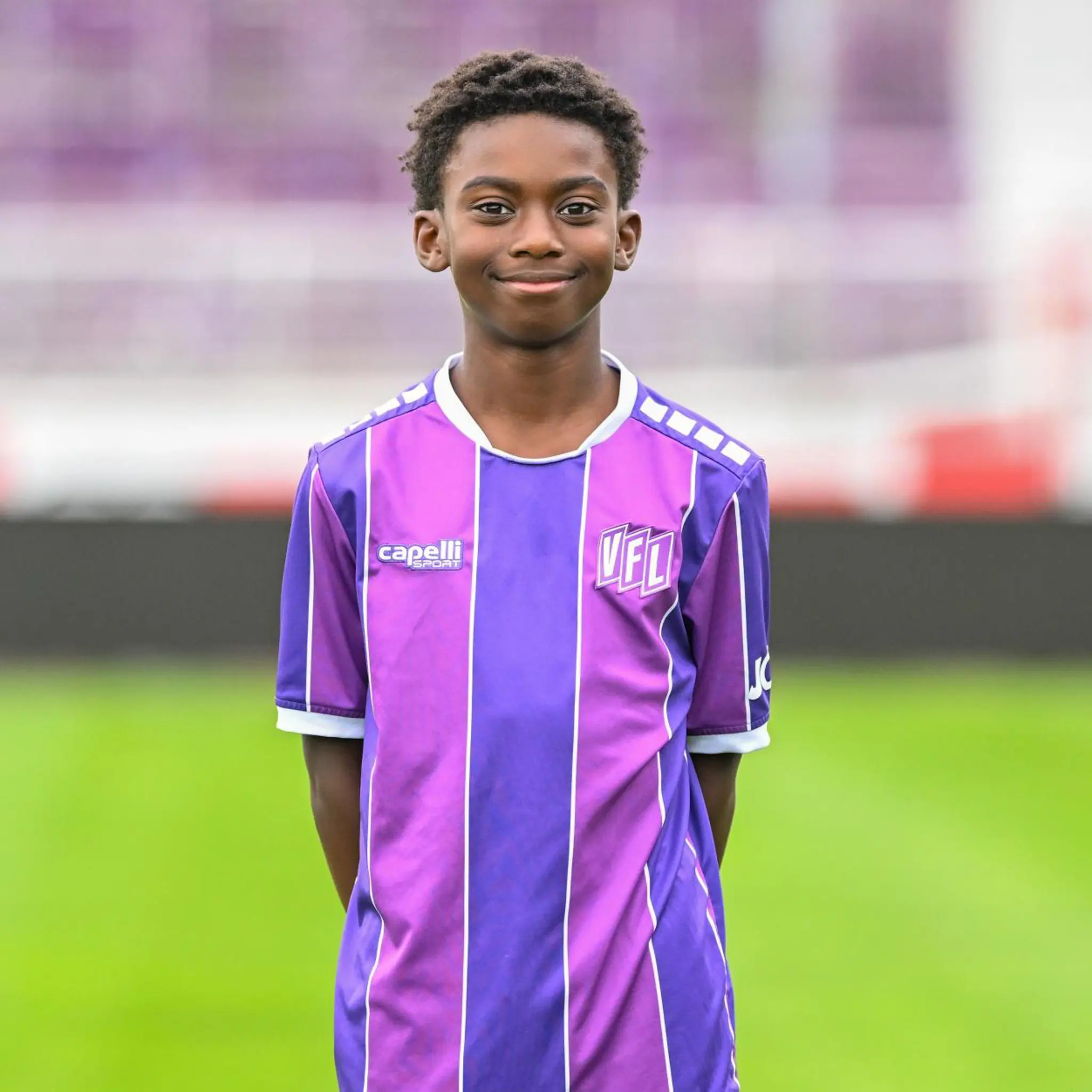 Aziz Badjie im Fußballtrikot. Junger Fußballspieler im lila-weiß gestreiften Trikot.