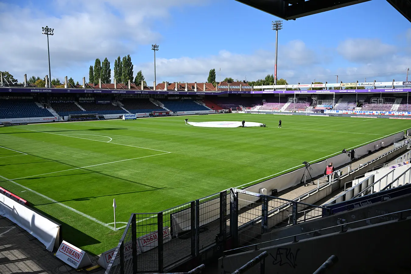 Blick auf das leere Fußballstadion an der Bremer Brücke mit gepflegtem Rasen und Tribünen bei sonnigem Wetter